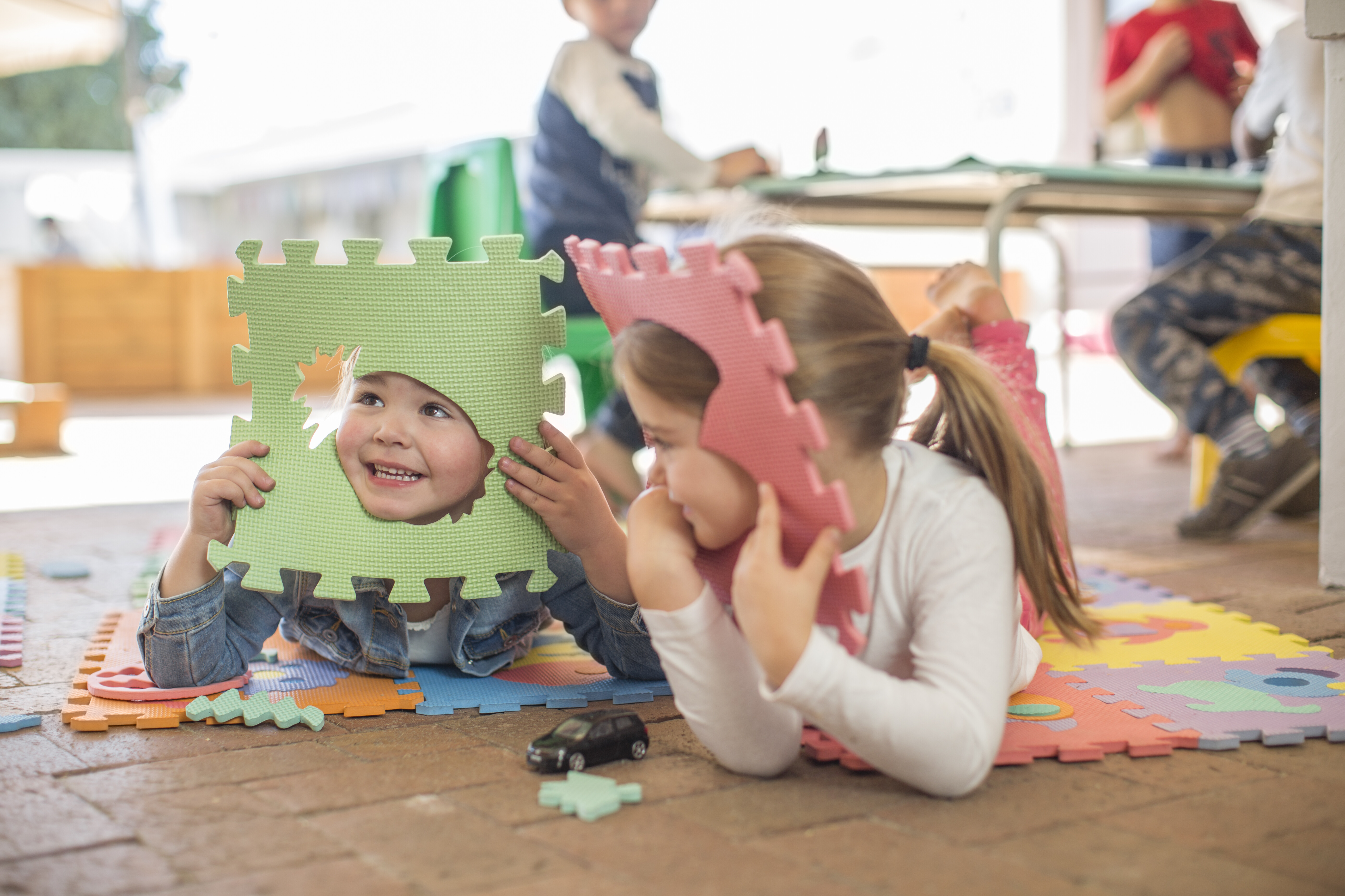 children peeking through puzzle mats
