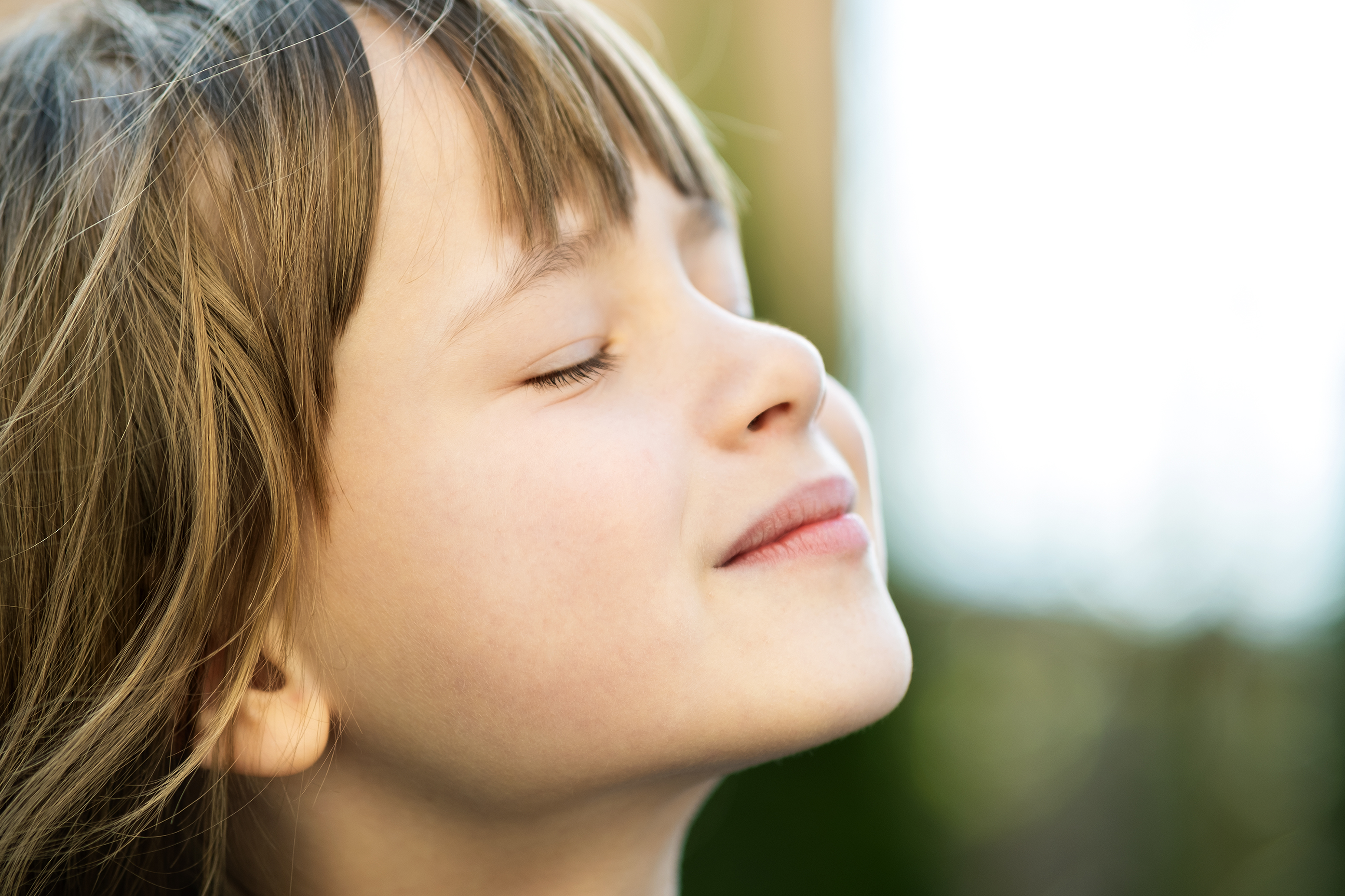 side profile of a young girls face, eye eyes closed