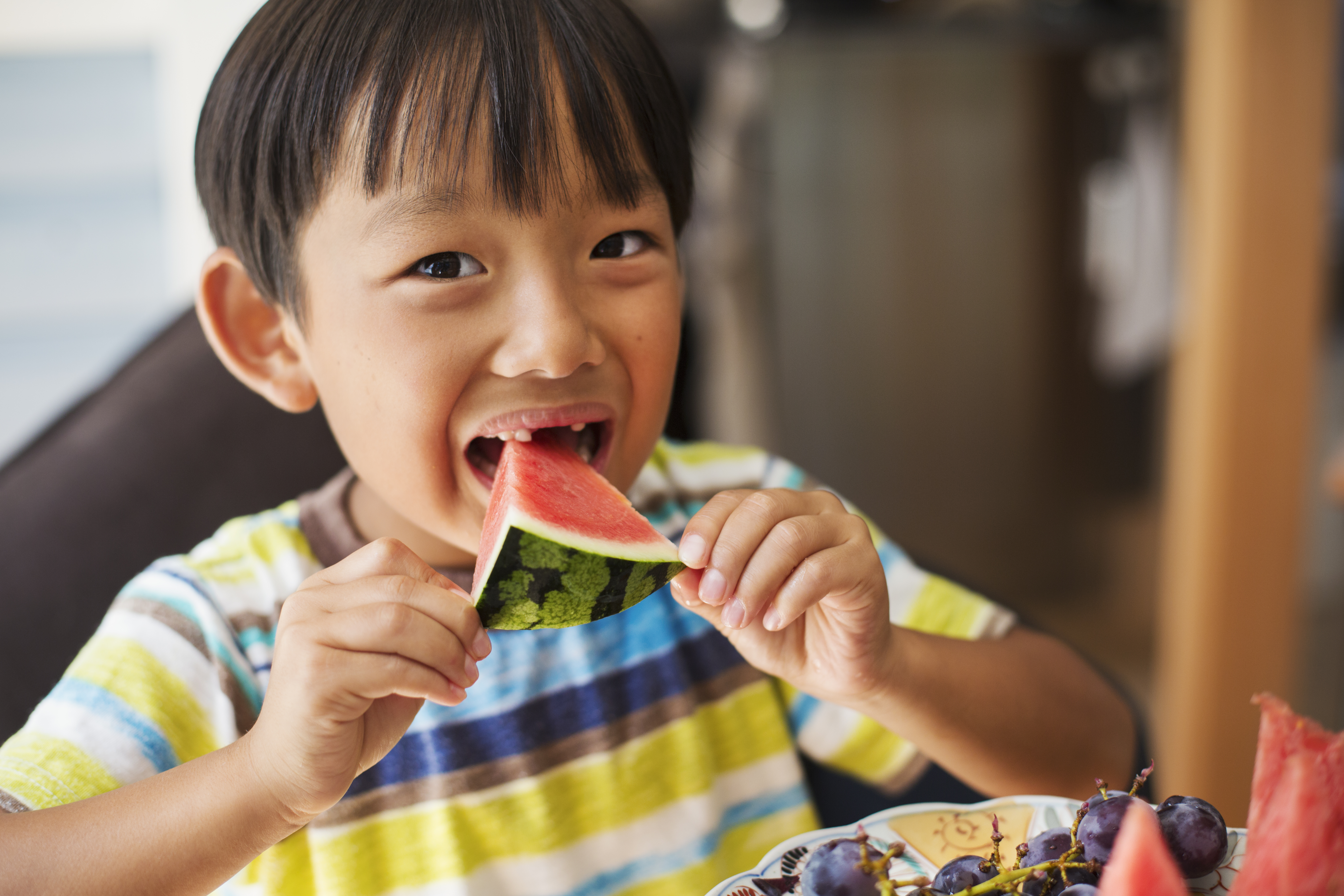 little boy eating a slice of watermelon