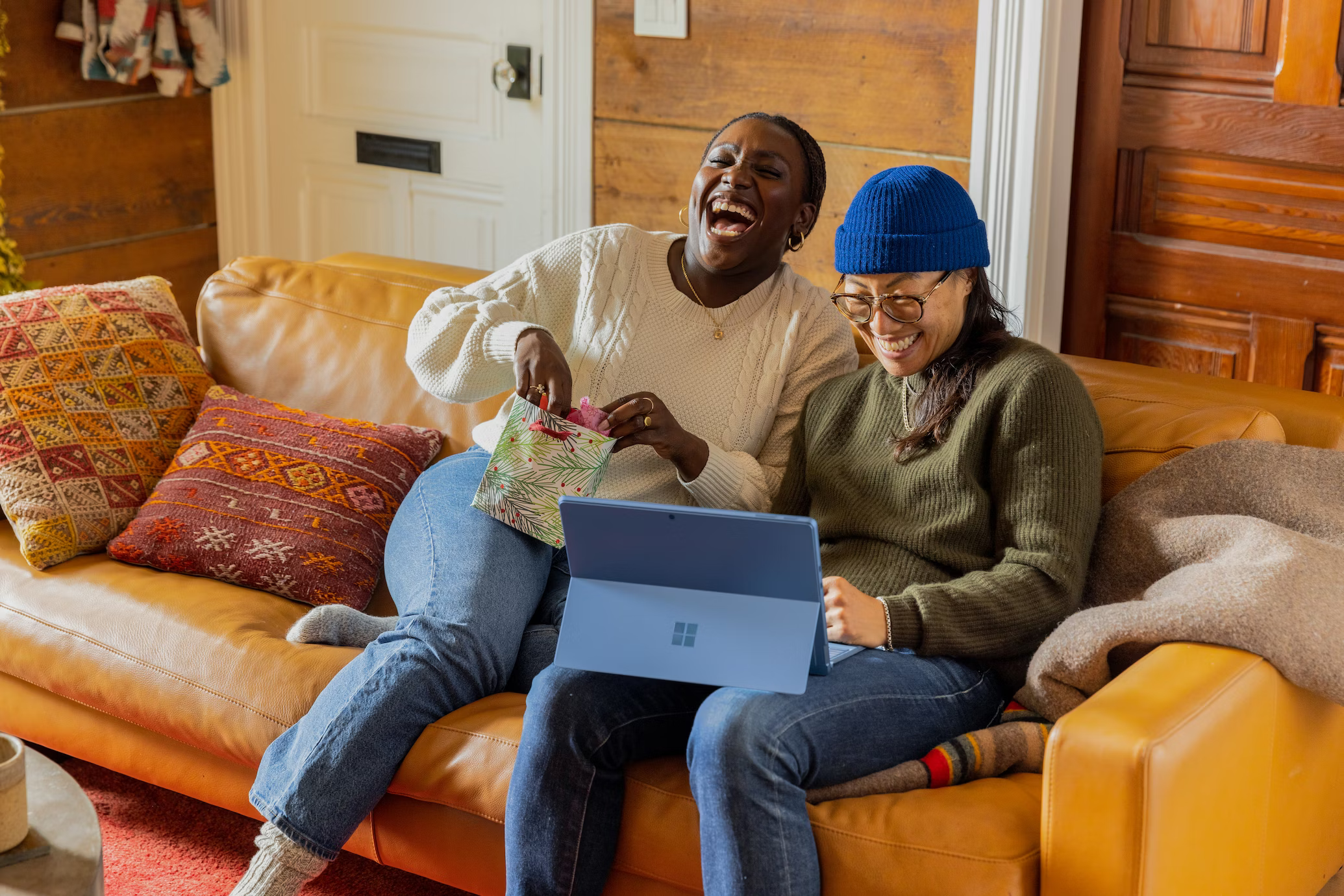 Two people sitting on a couch laughig