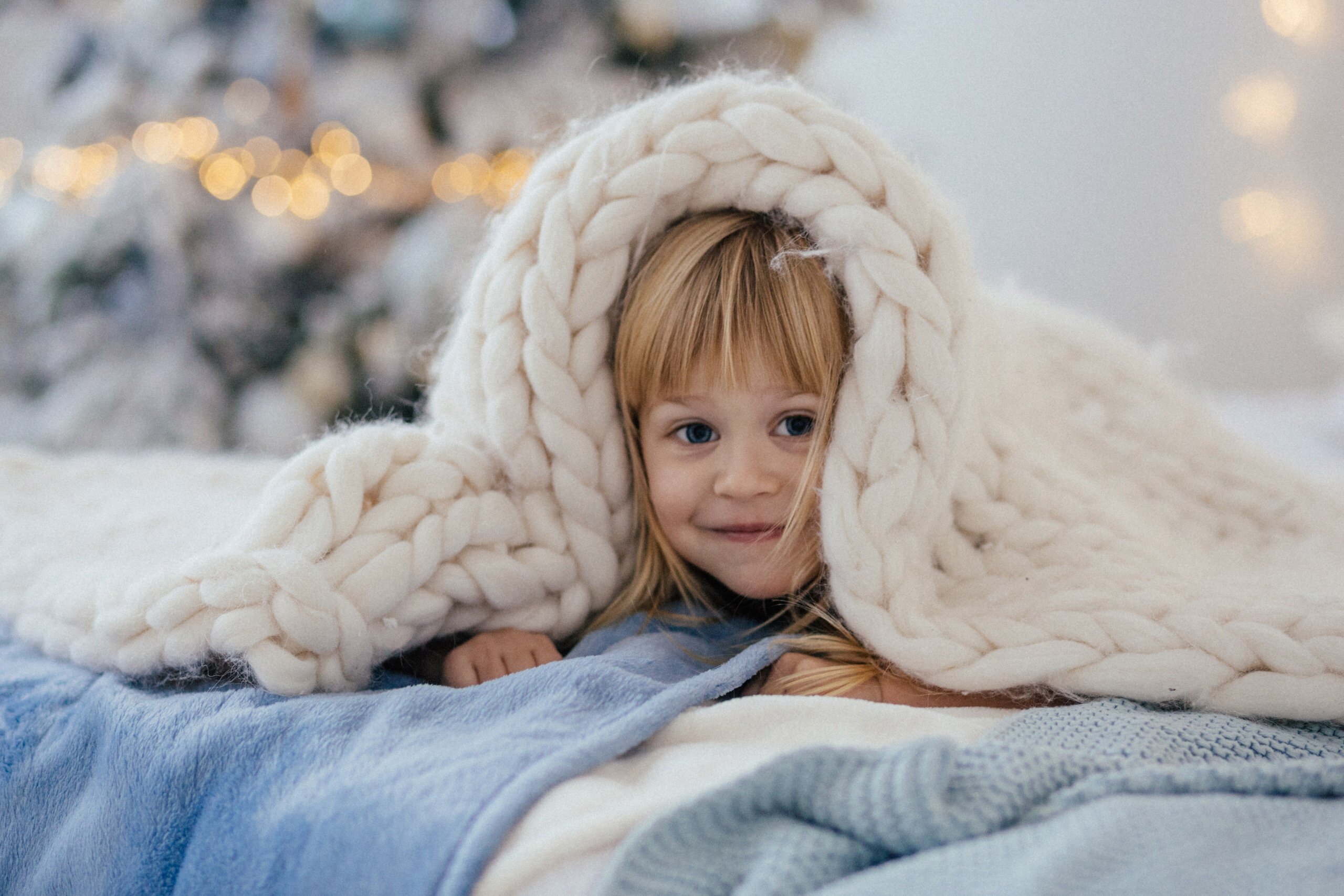 a child hiding under a blanket