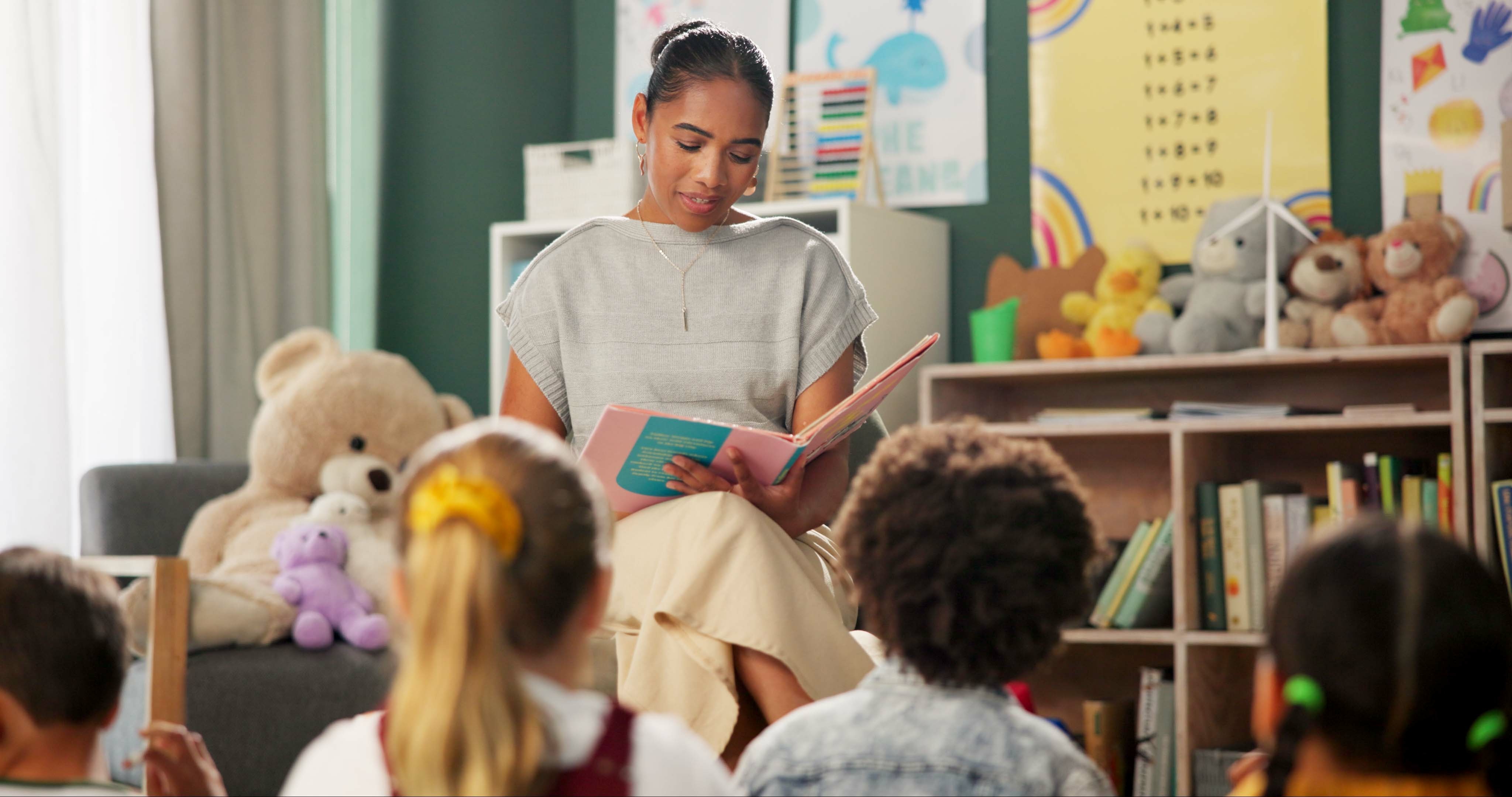 teacher reading a book to a classroom of young children