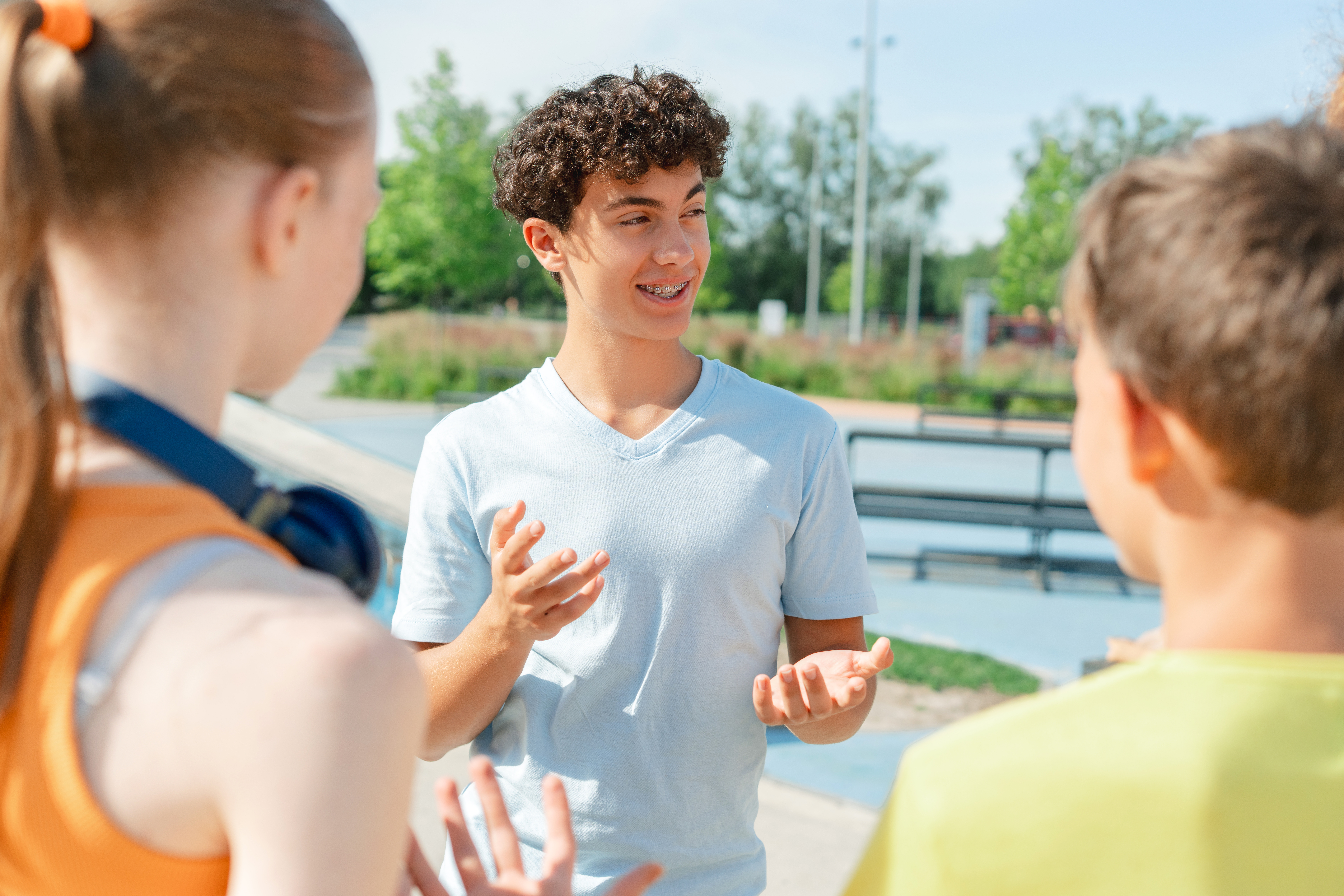 three teenagers talking at a party