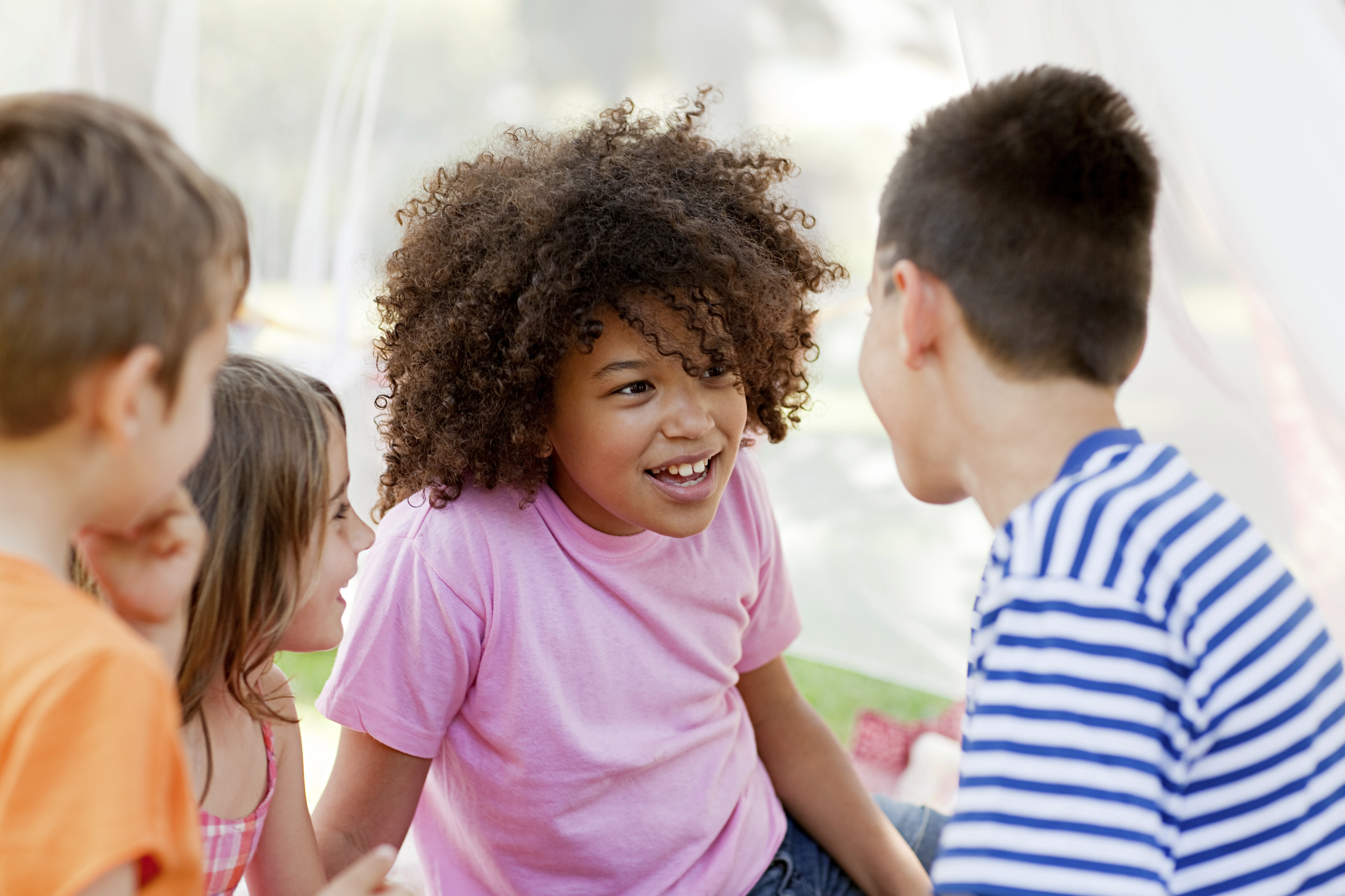 four kids smiling and talking