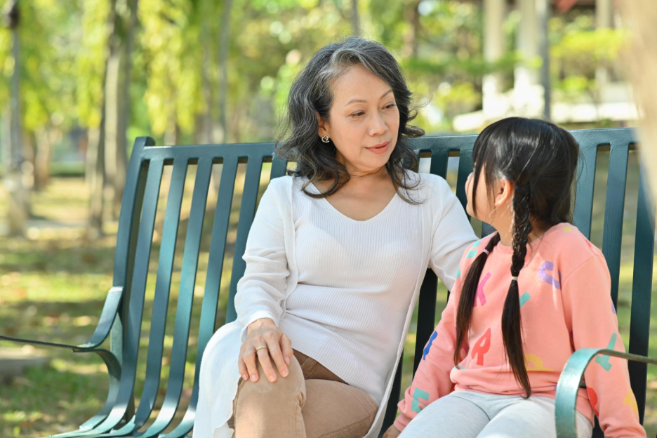 adult and child talking on a bench