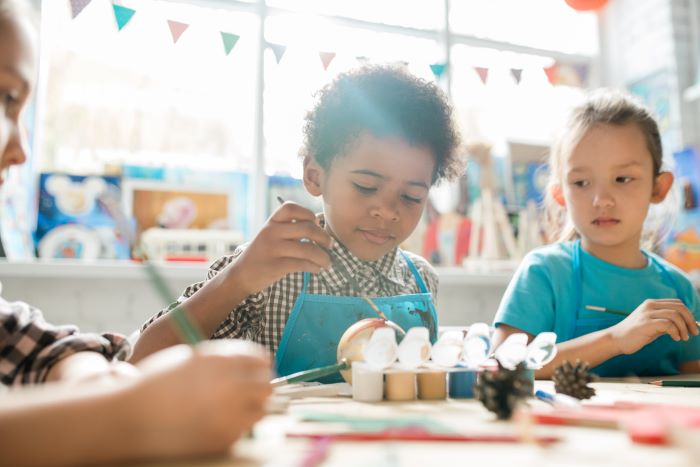 young children painting in a classroom setting