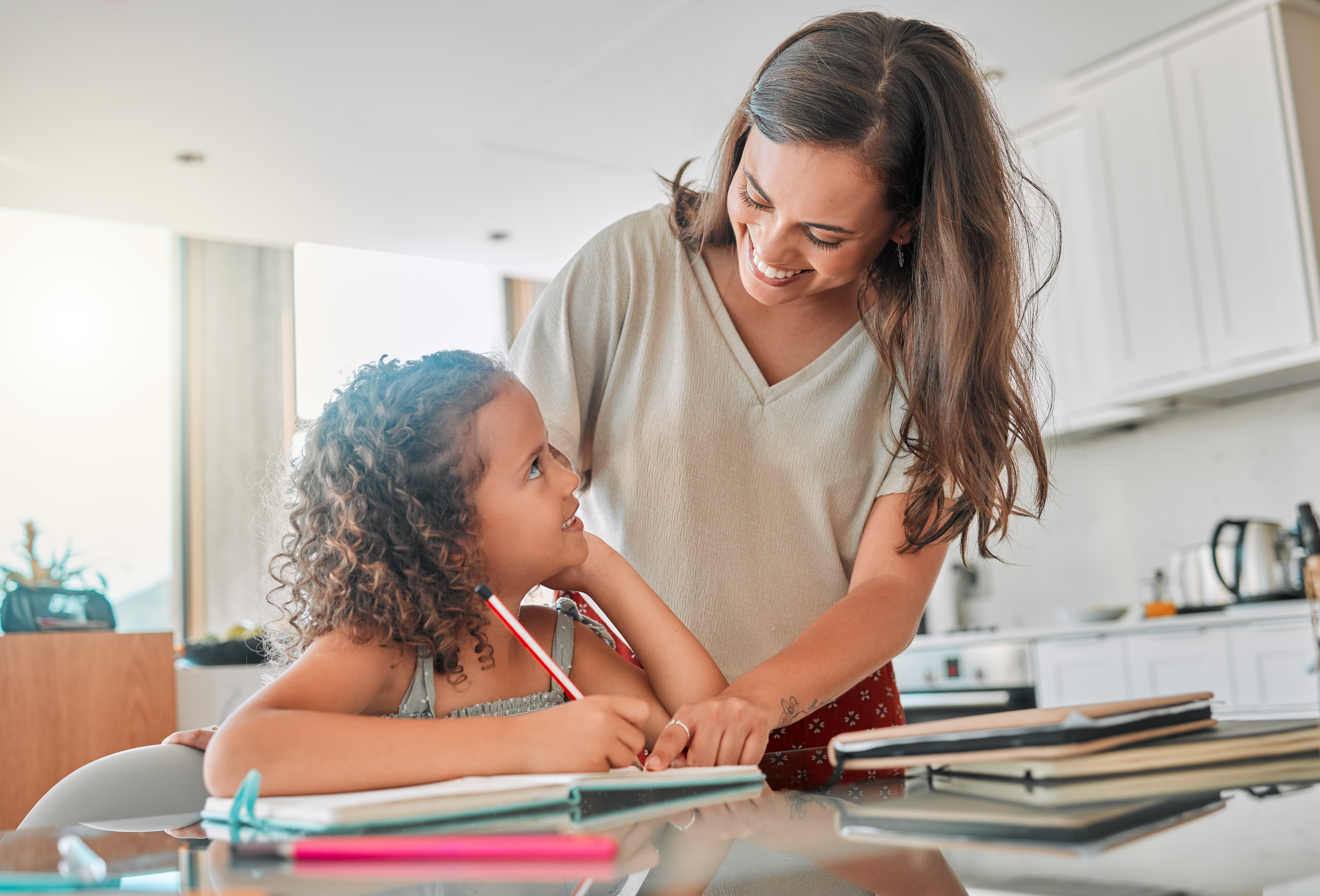 young girl doing homework with mother's help