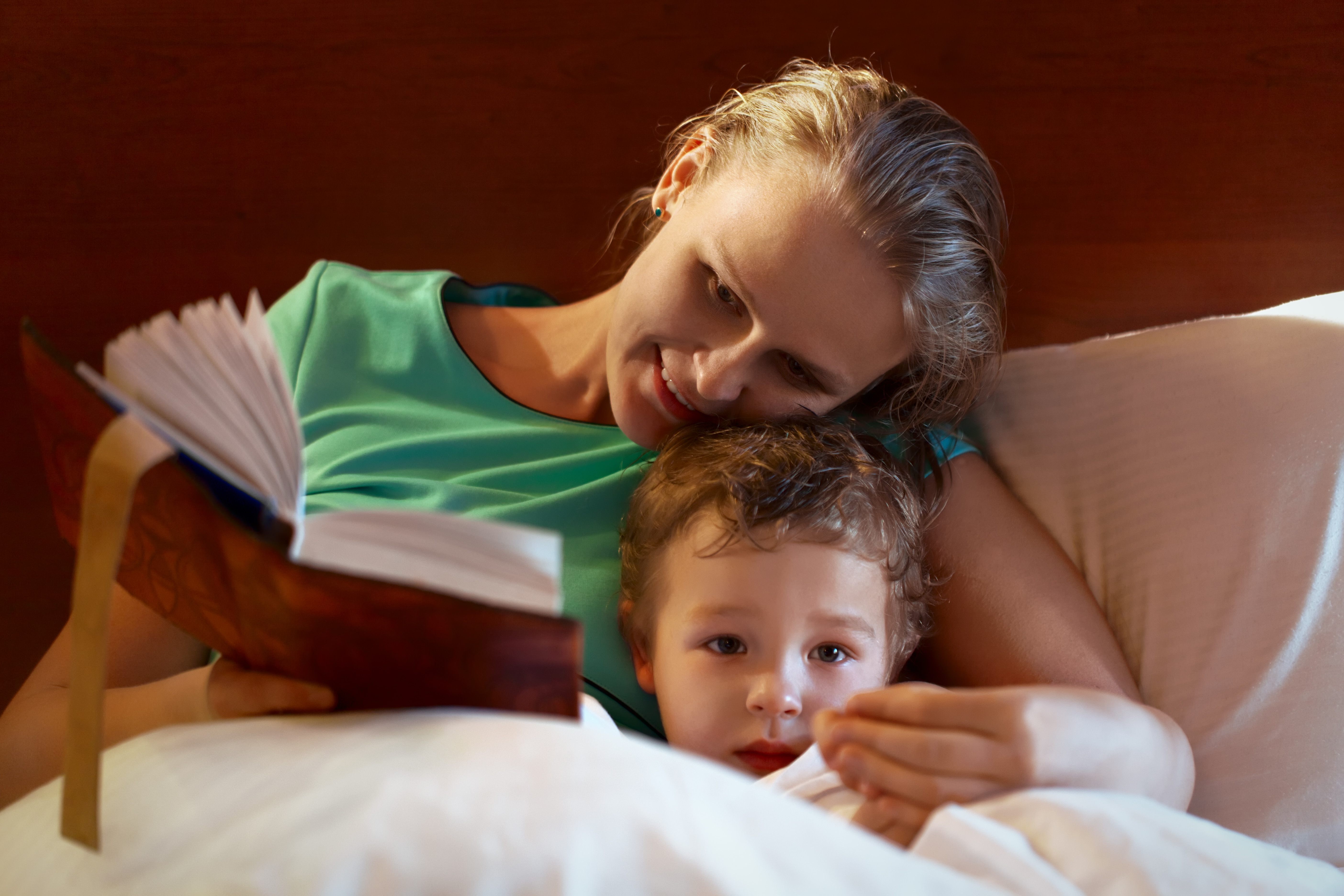 mother reading to her child in bed